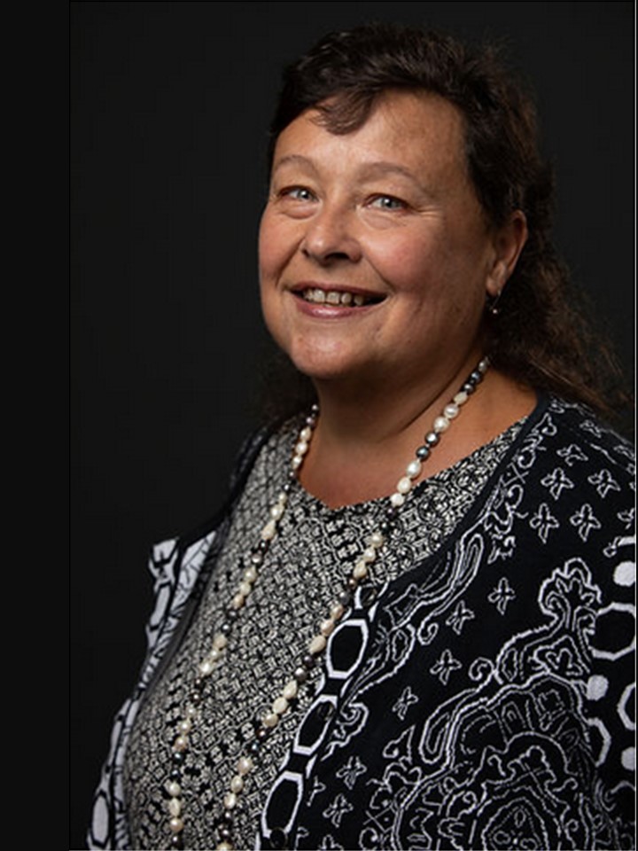 Photo of Eliana Lobo, a woman with short dark hair in a black and white patterned outfit with matching necklace