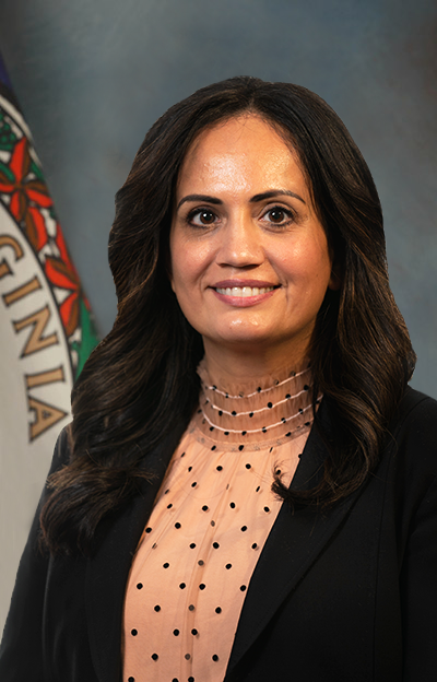 Photo of Mona Siddiqui, a Brown woman with wavy dark hair in a pink top wiht a black jacket