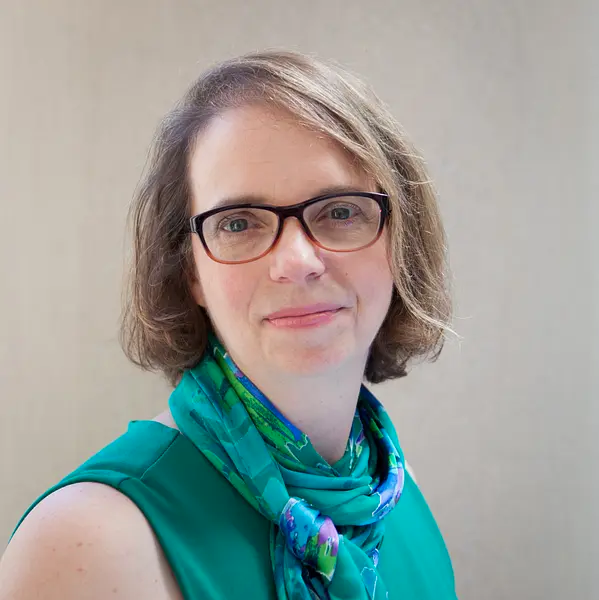 Photo of Victoria "Tori" Smith Ekstrand, a woman with short light brown hair and brown glasses in a blue-green scarf and top.